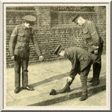 A corporal instructs a recuit how properly to adjust his puttees.