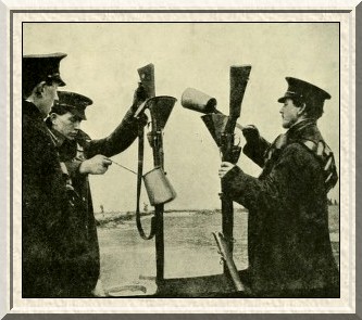 Soldiers cleaning their rifles by pouring boiling water down the
barrels.