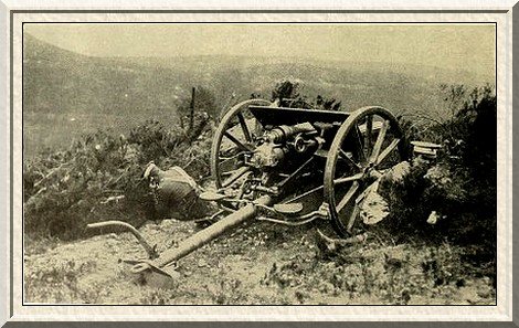 A gun under cover. An artilleryman is receiving orders by telephone.